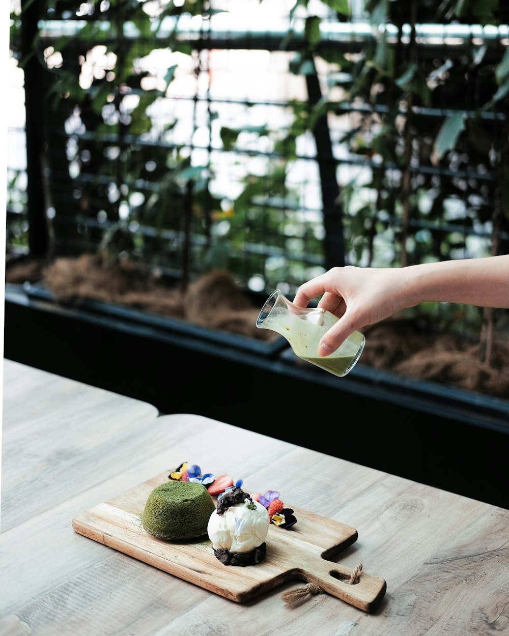 person pouring green liquid on pastries