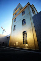 Modern building facade with golden accents and red structural elements under construction