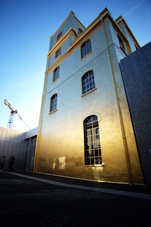 A completed multi-story building with golden accents reflecting the amber construction brand colors.