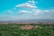 A vibrant landscape of Yucatán featuring lush greenery and ancient ruins under a clear blue sky.