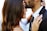 man kissing woman on her forehead