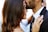 man kissing woman on her forehead