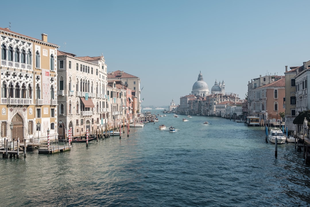 boats running on sea between buildings