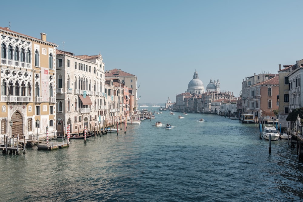 boats running on sea between buildings