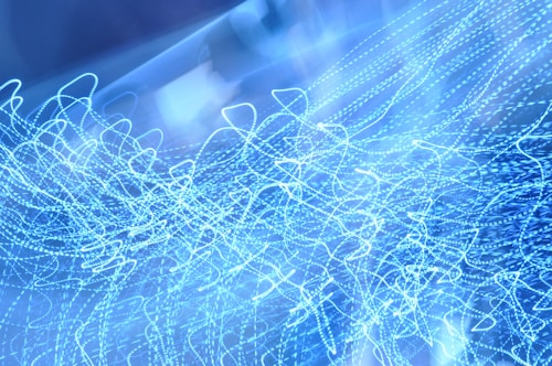 A captivating array of abstract, swirling blue light patterns creates a sense of movement and energy.