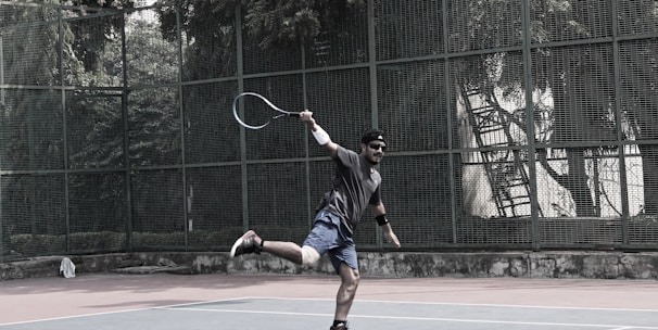 A dynamic tennis player hitting a forehand shot on a sunny outdoor court.