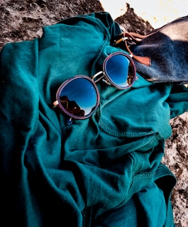 Close-up of stylish sunglasses with reflective lenses resting on a vibrant fabric