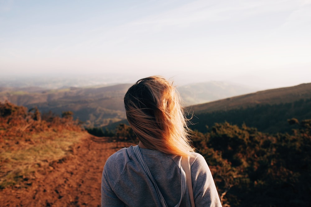 woman standing while looking on mountain range