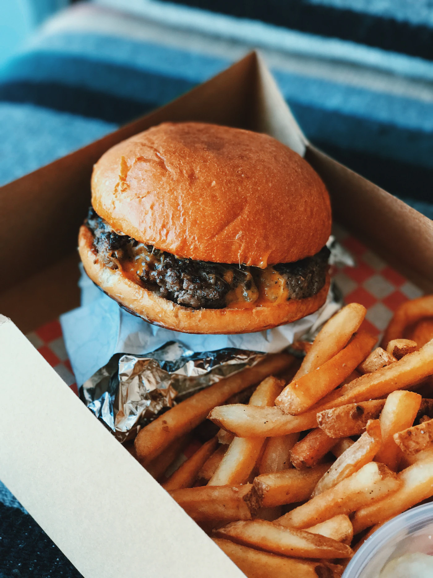 Burger et frites dans une boîte à emporter ouverte