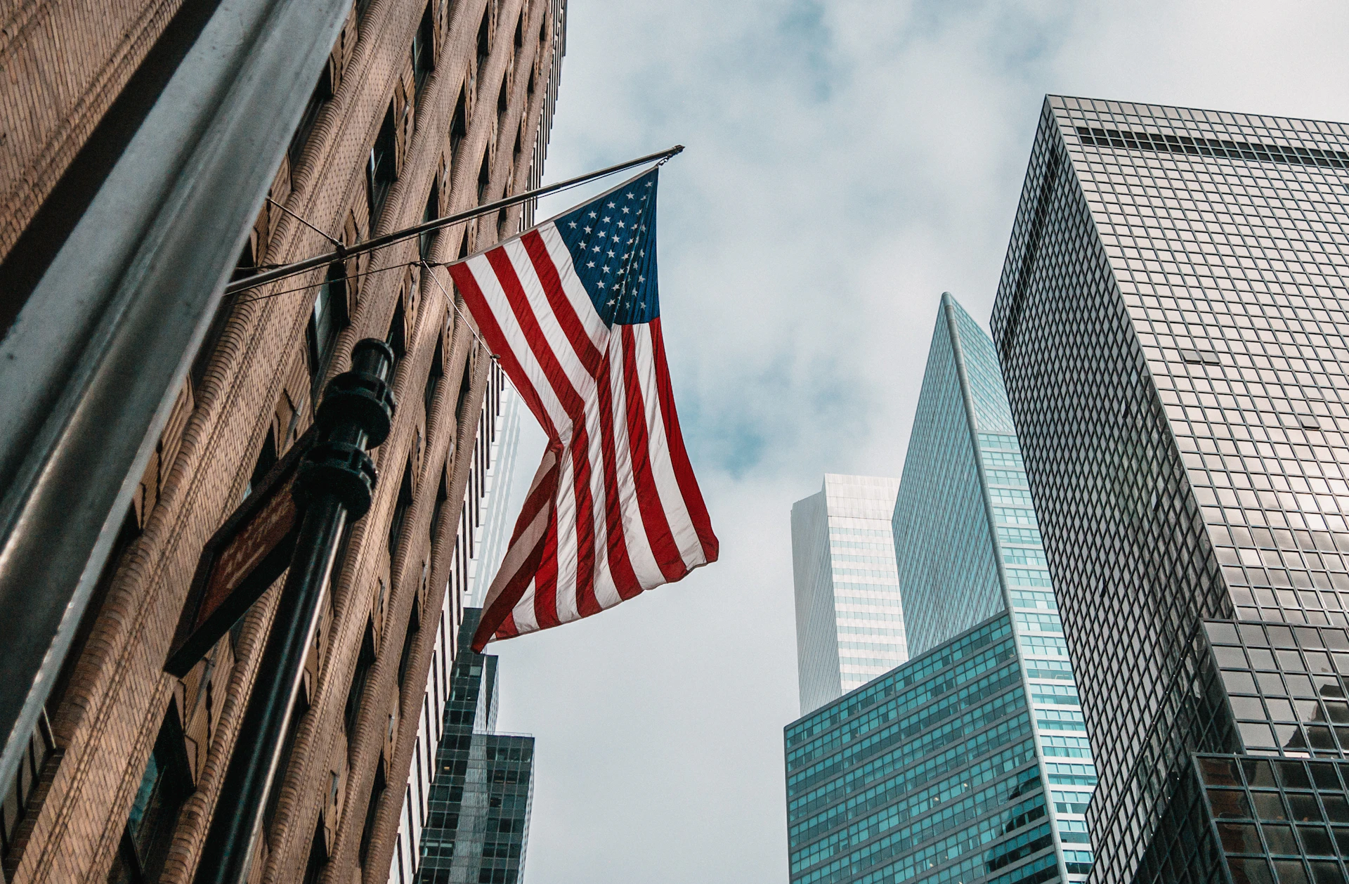 American flag flying above a city street