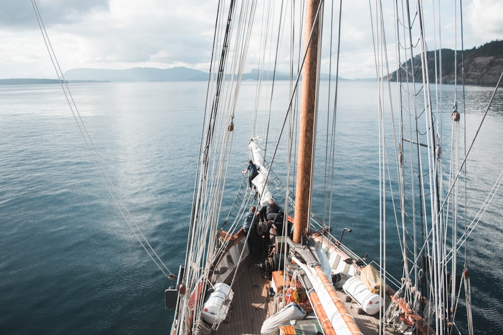 white and brown boat sailing on body of water