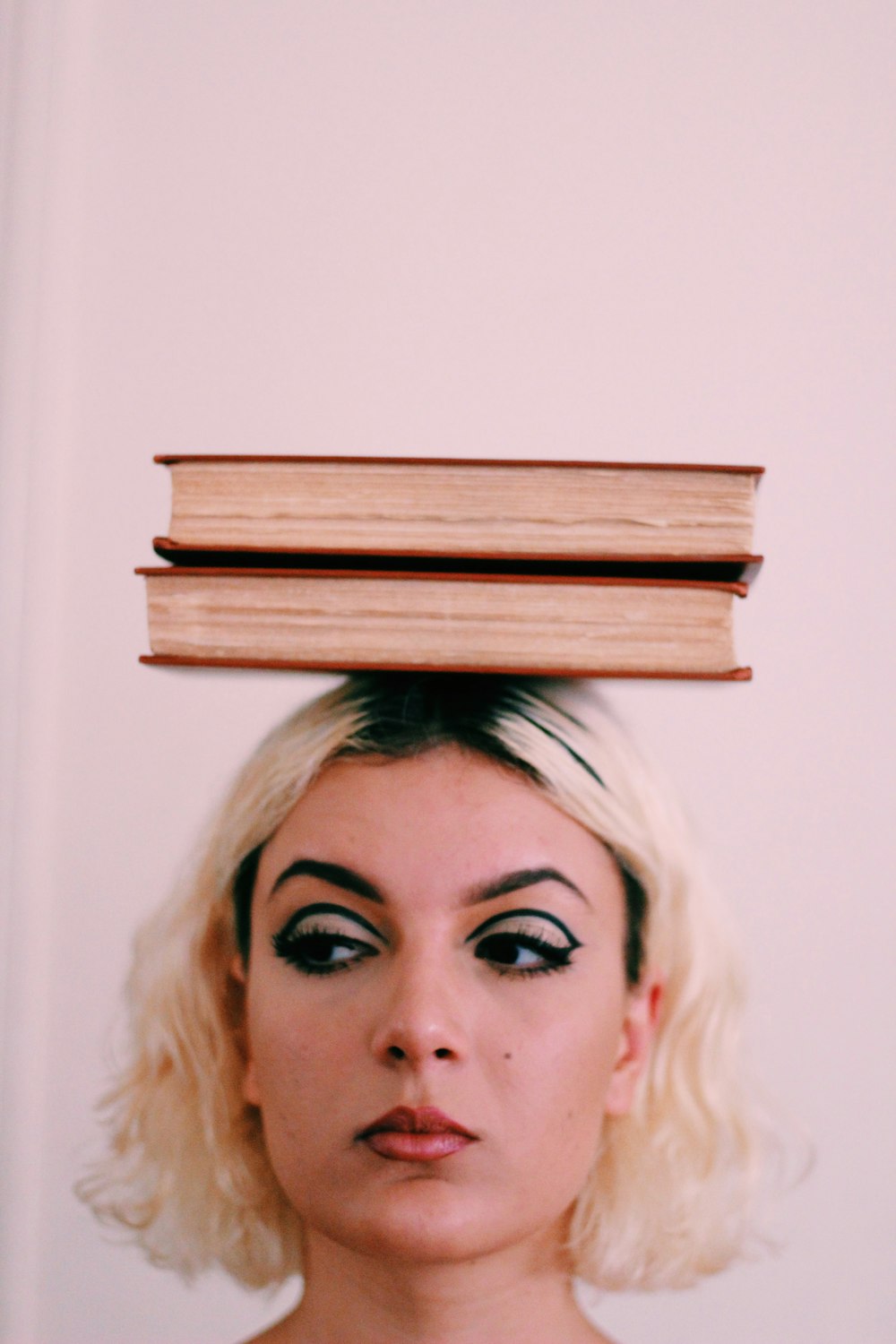 two books on top of woman's head