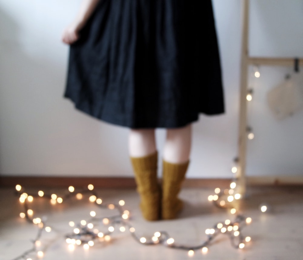 person standing beside string lights