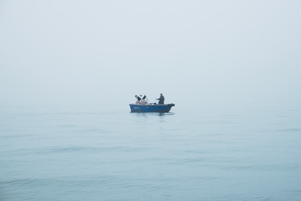 people riding blue boat on body of water