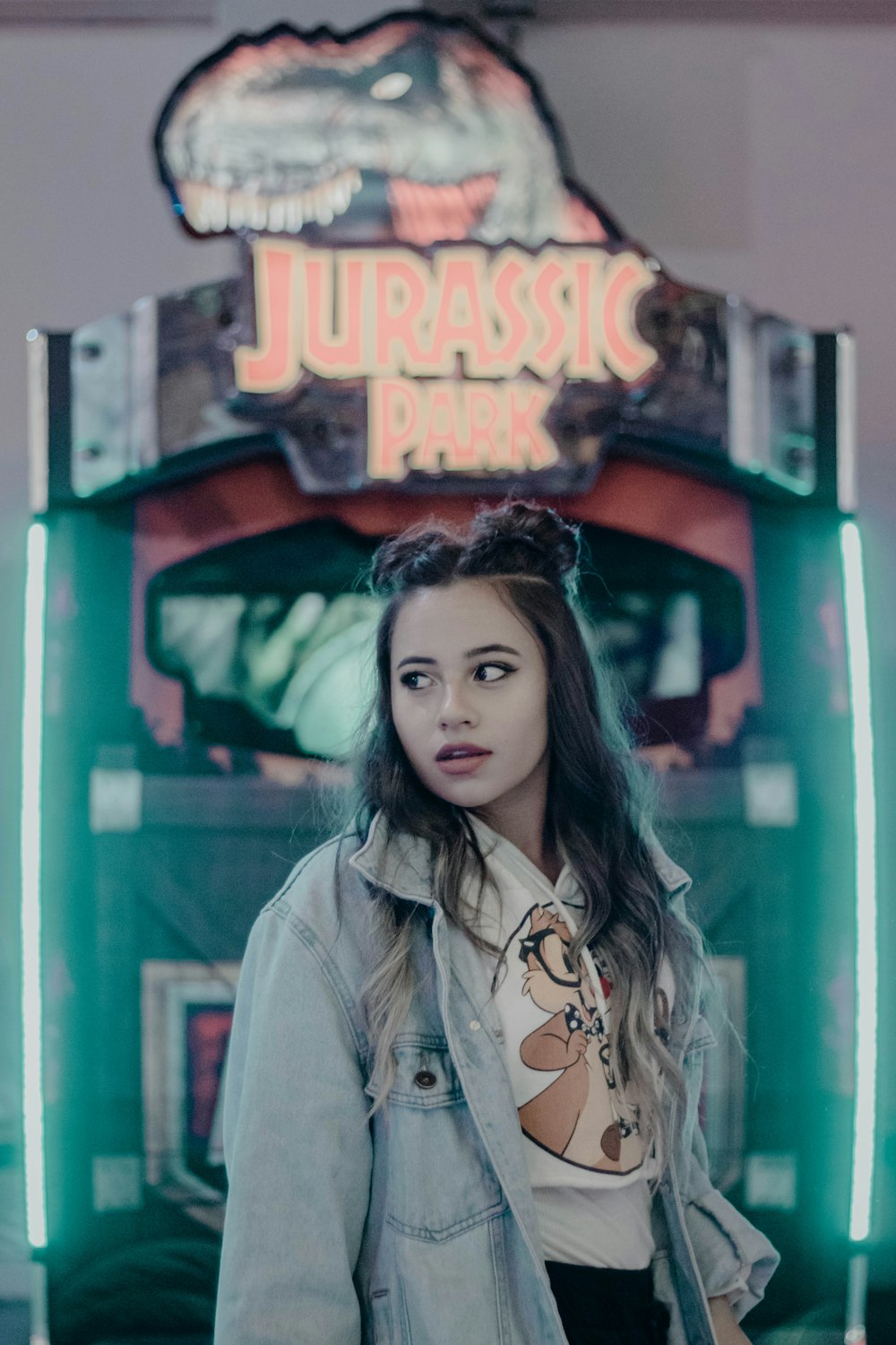 femme debout devant la machine de jeu d’arcade Jurassic Park