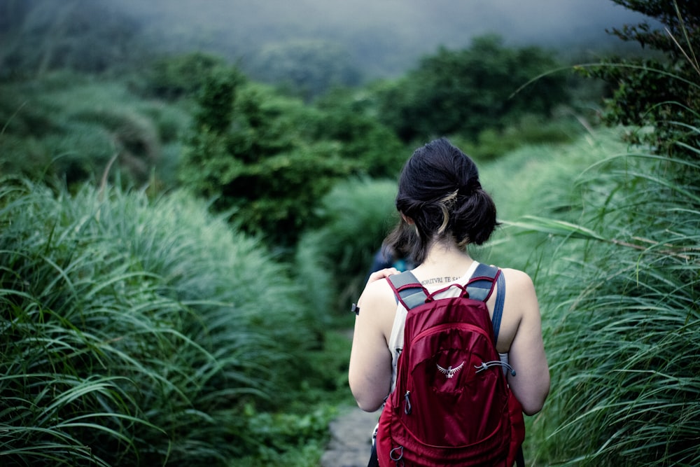 woman walking towards forest