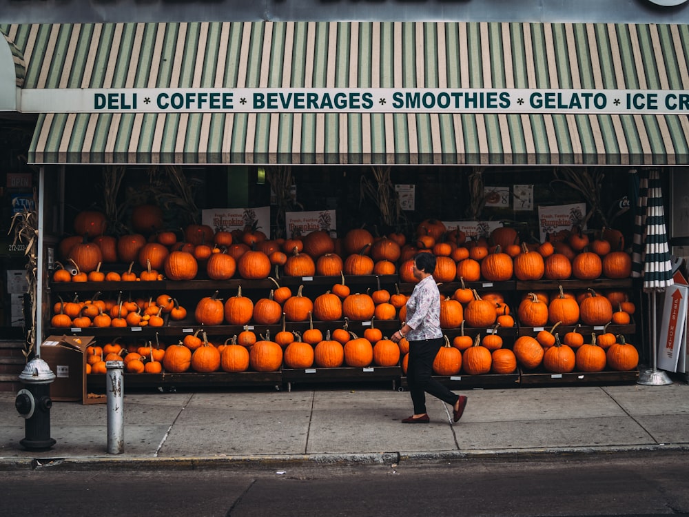 woman walking along pumpkin store