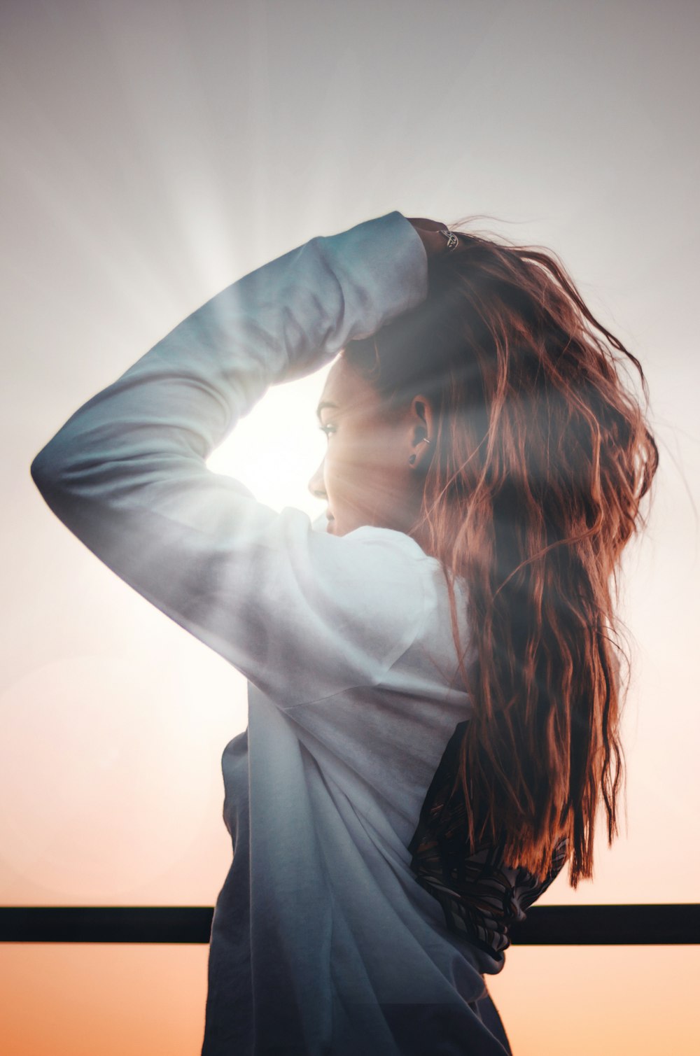 woman holding her hair during sunset