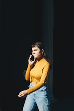 woman walking with phone on her right ear during daytime