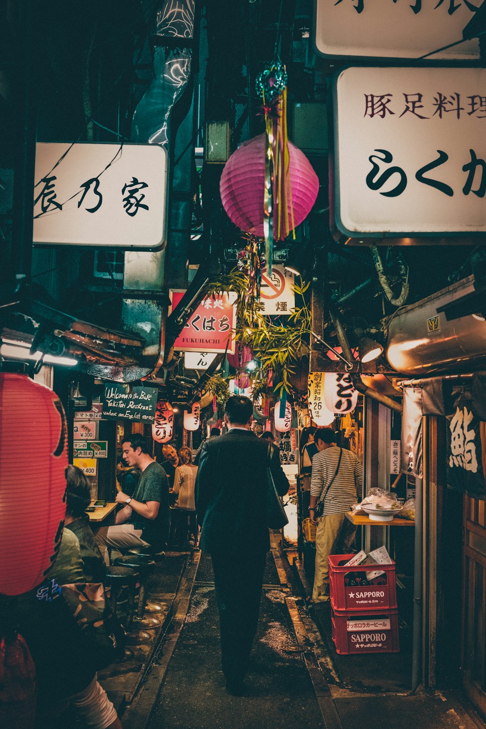 夜間に店の間を歩く男性