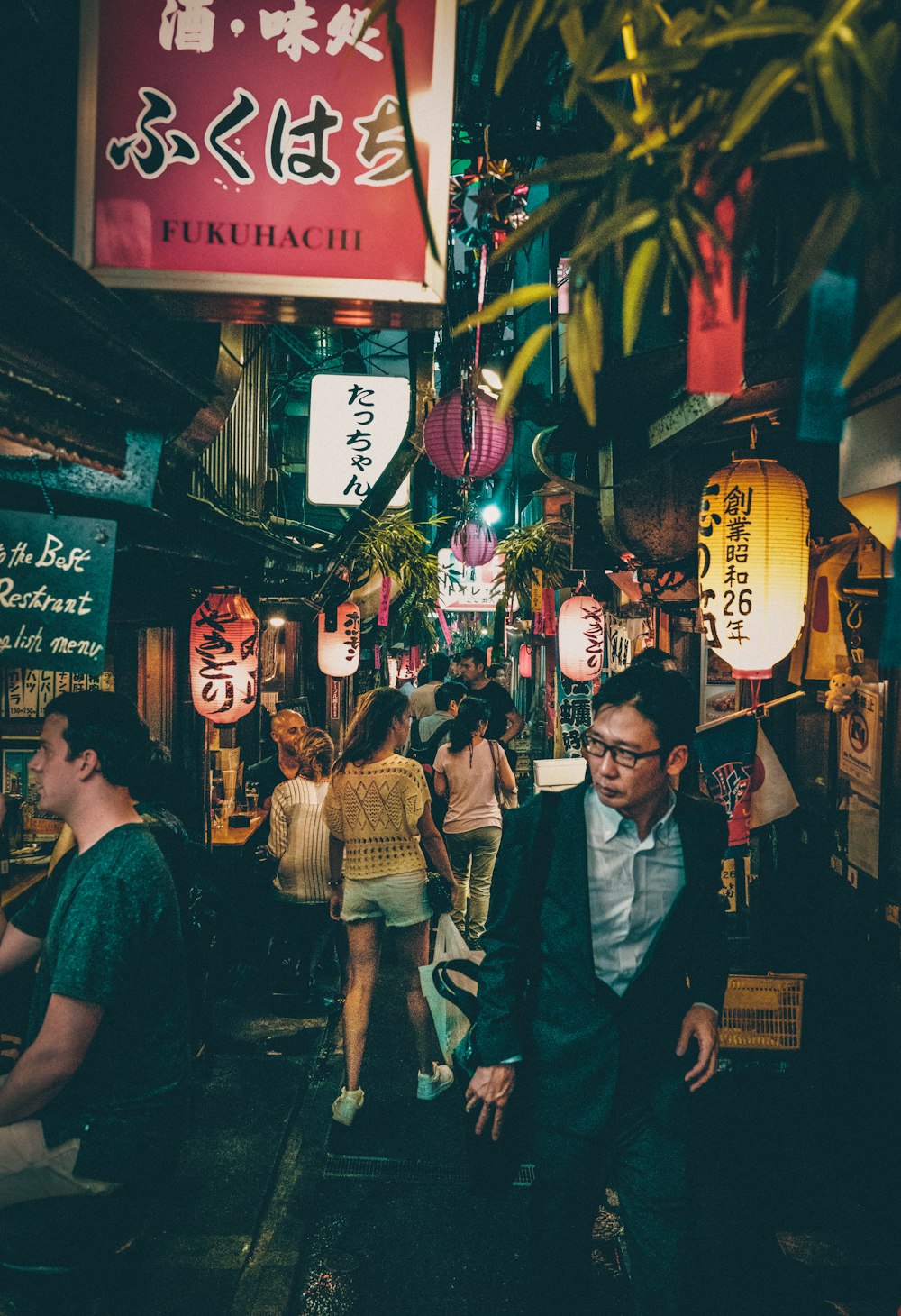 people walking between building at nighttime