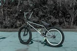 grayscale photo of BMX bike on concrete pavement