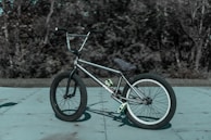 grayscale photo of BMX bike on concrete pavement