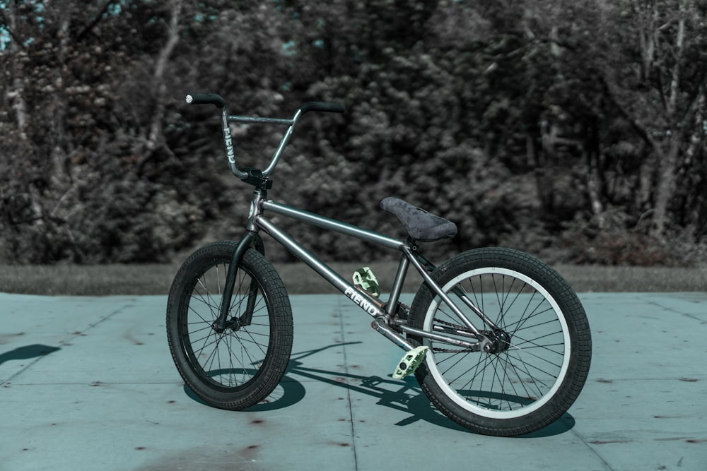 grayscale photo of BMX bike on concrete pavement