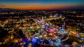 A scenic view of a theme park at sunset with lights beginning to glow.