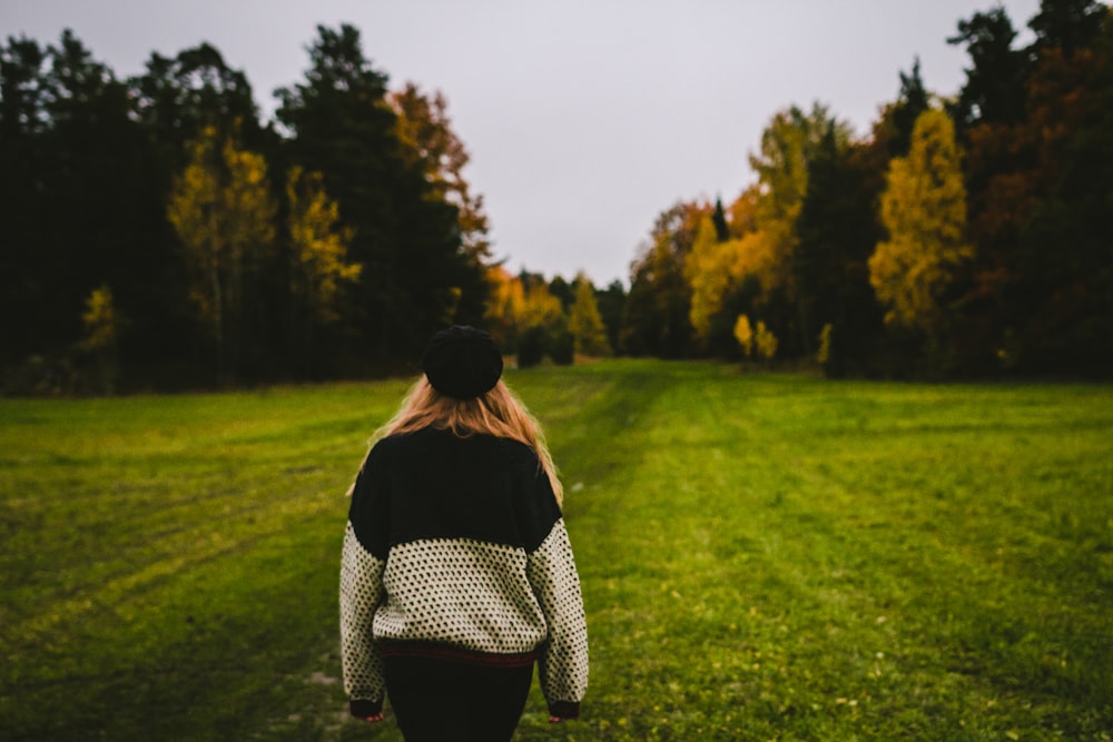 woman wearing sweater standing on green grass