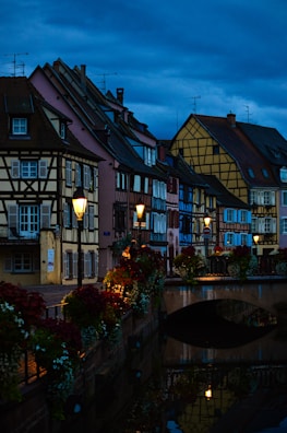 A quaint medieval street in Bruges lined with colorful brick houses under a soft sunset glow.