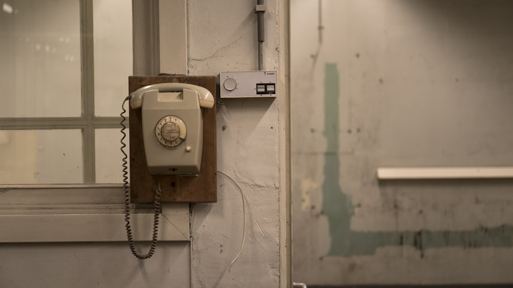 an old phone is hanging on a wall