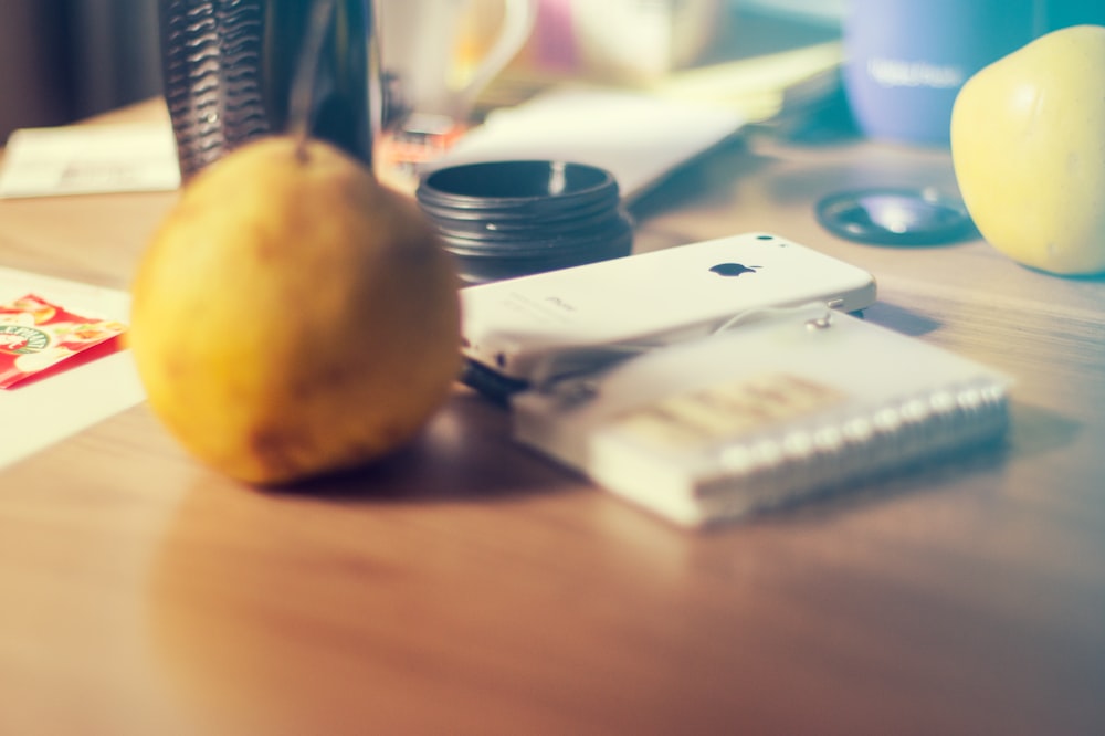 a table with a lemon, a cell phone, and other items