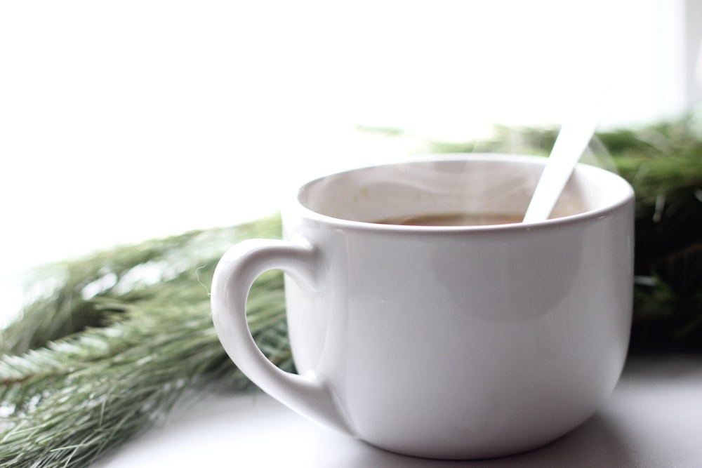 white ceramic mug with brown liquid