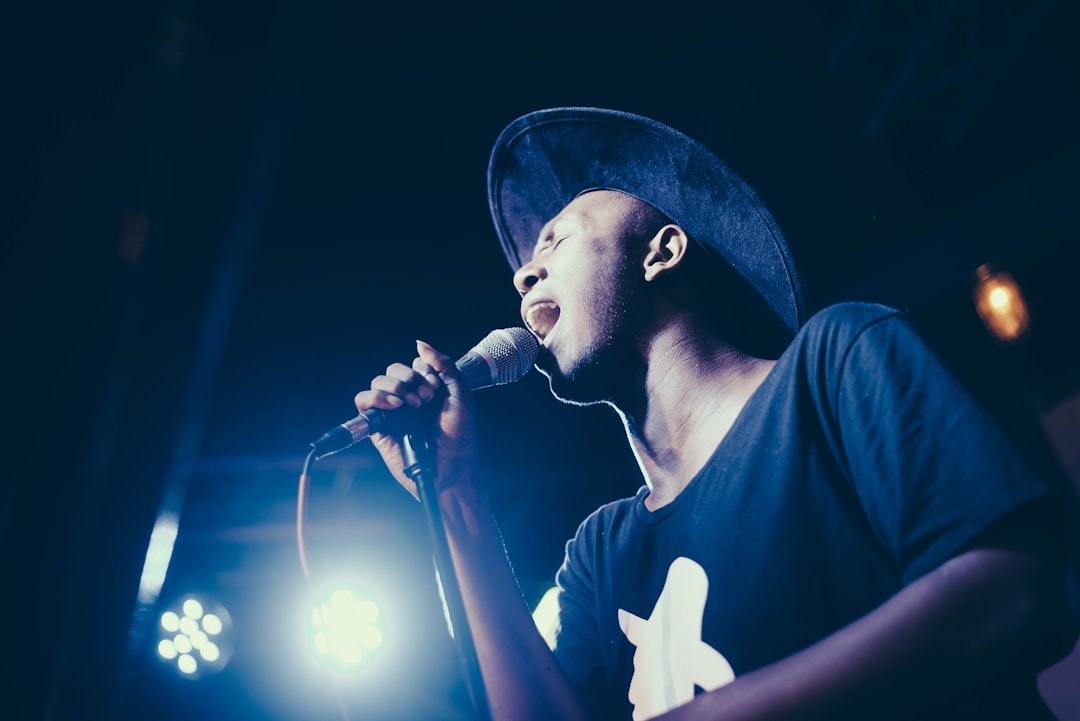 low angle of man wearing cap singing in microphone
