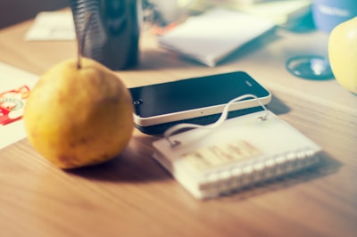 Close-up of a conference table where guests are charging phones on a sleek PromesaEvents table device showing the event schedule.