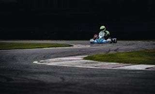 person riding go kart racing on race track