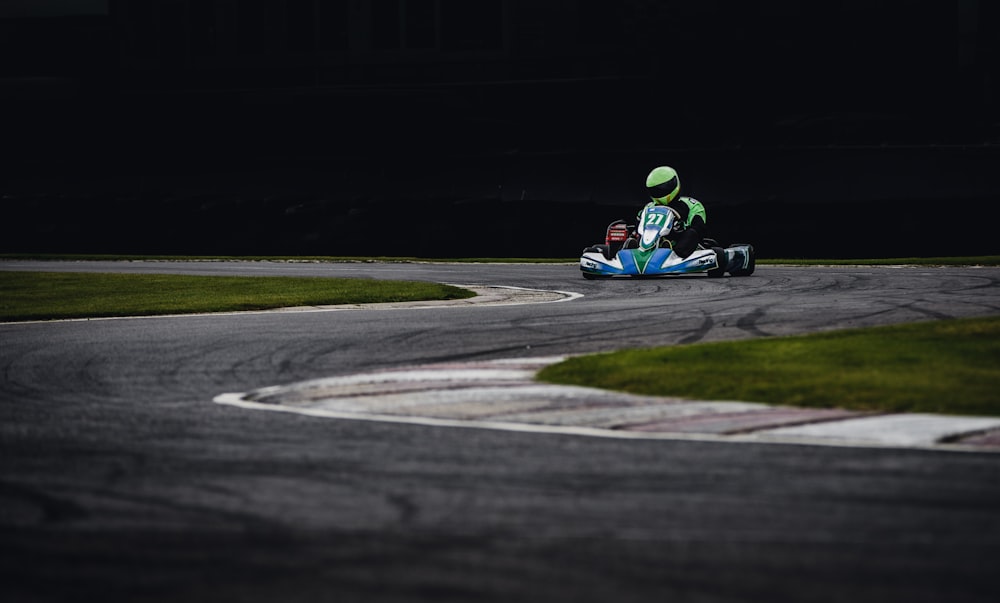 person riding go kart racing on race track