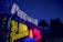 Bright neon signs are illuminated against a nighttime backdrop, displaying 'Peppermill' and '24 Hour Restaurant' in vibrant colors. There is a palm tree silhouetted against the deep blue sky.