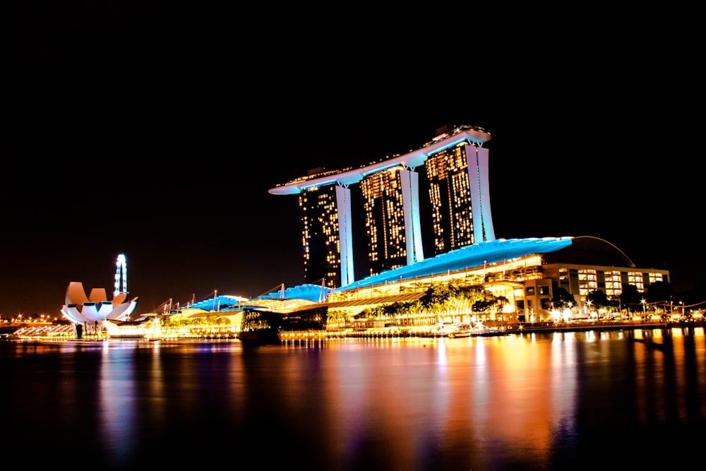 blue and yellow building fully lighted and surrounded with body of water