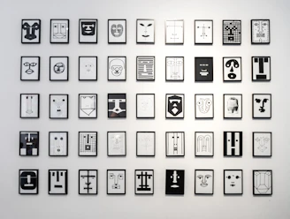 A collection of minimalist black and white line art prints displayed on a wall.