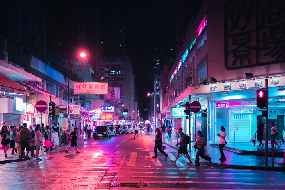 people walking on pedestrian lane between building at nighttime