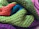Close-up photo of a handmade knitted bag with intricate patterns and warm colors.