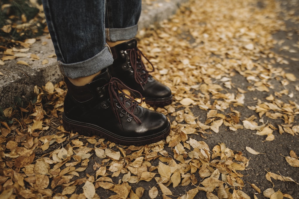 person wearing black leather work boots