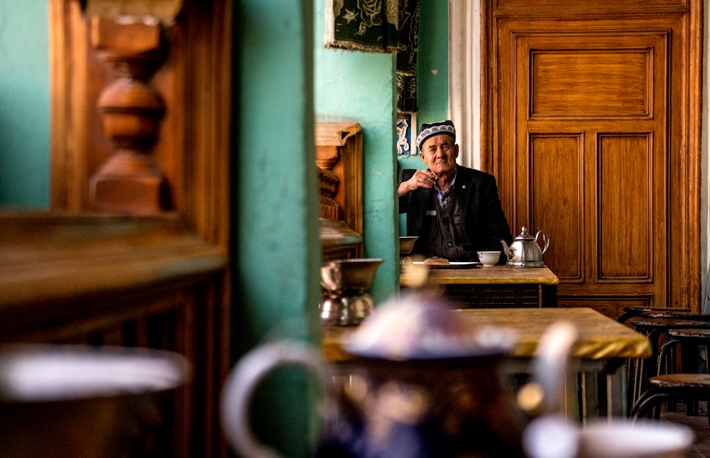 homme assis devant une table près de la porte