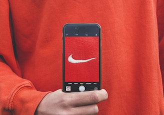 person holding iPhone taking picture on Nike label