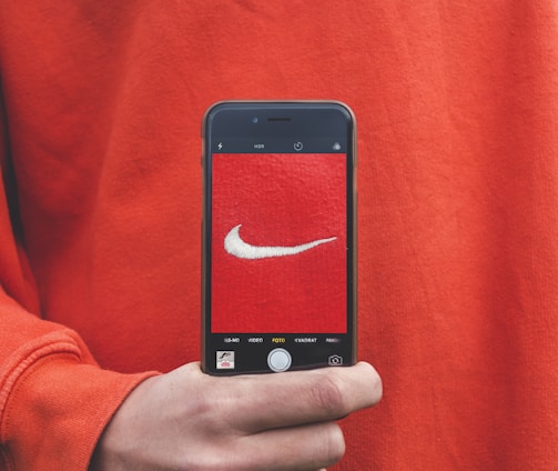 person holding iPhone taking picture on Nike label