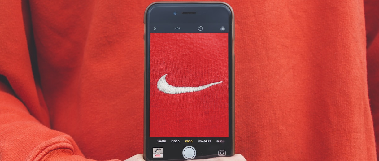 person holding iPhone taking picture on Nike label