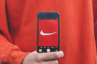 person holding iPhone taking picture on Nike label