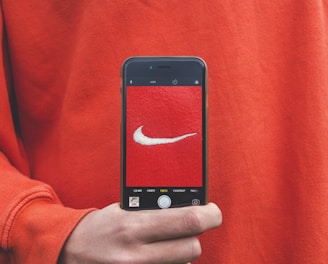 person holding iPhone taking picture on Nike label